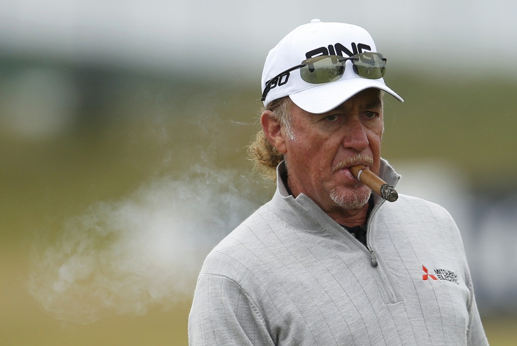 Jimenez of Spain smokes a cigar as he stands on the driving range during a practice round ahead of the British Open golf championship on the Old Course in St. Andrews, Scotland