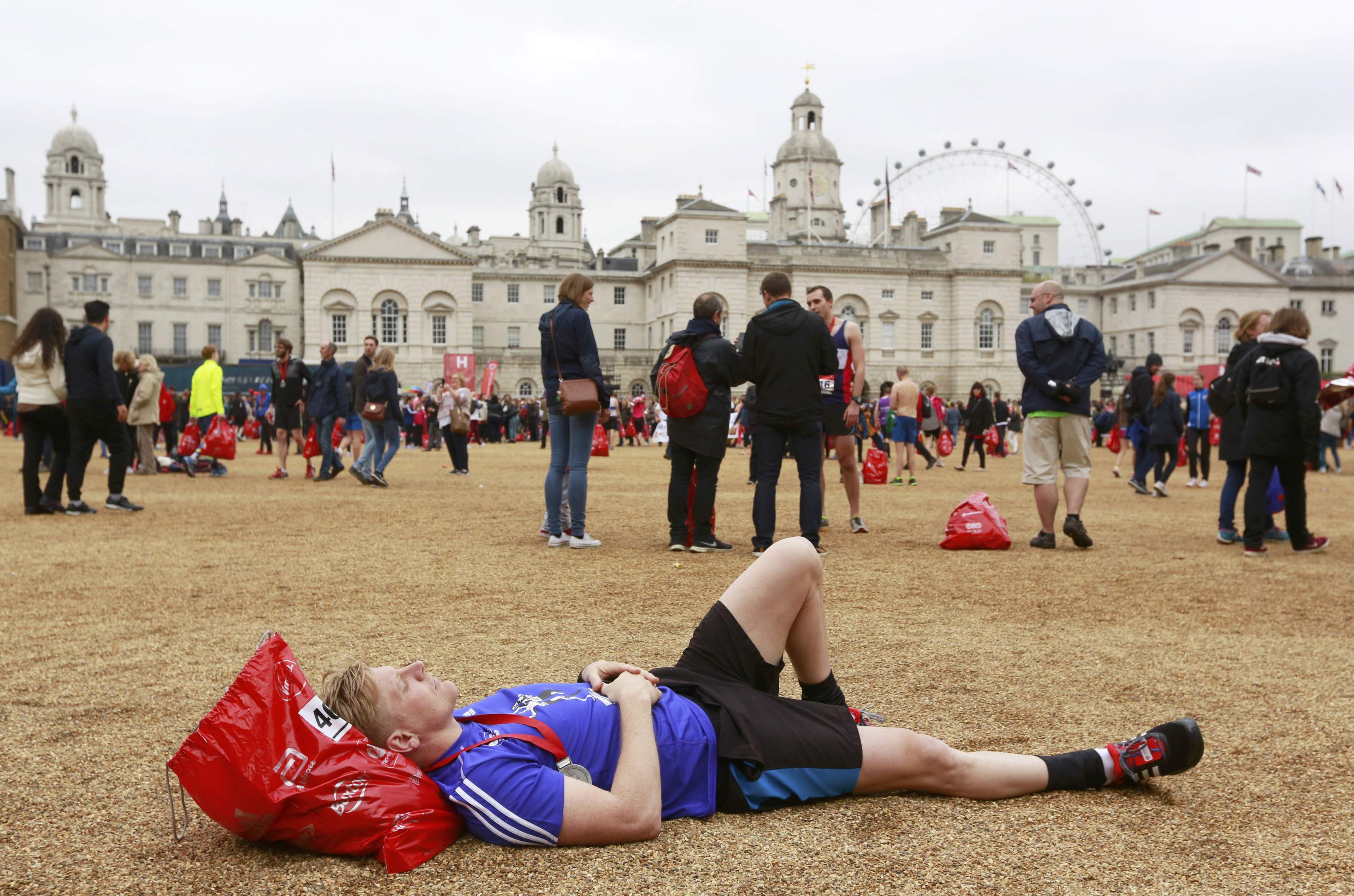 A runner rests on the gravel of Horse Guards Parade after finishing the London Marathon, April 26, 2015. REUTERS/Cathal McNaughton Picture Supplied by Action Images