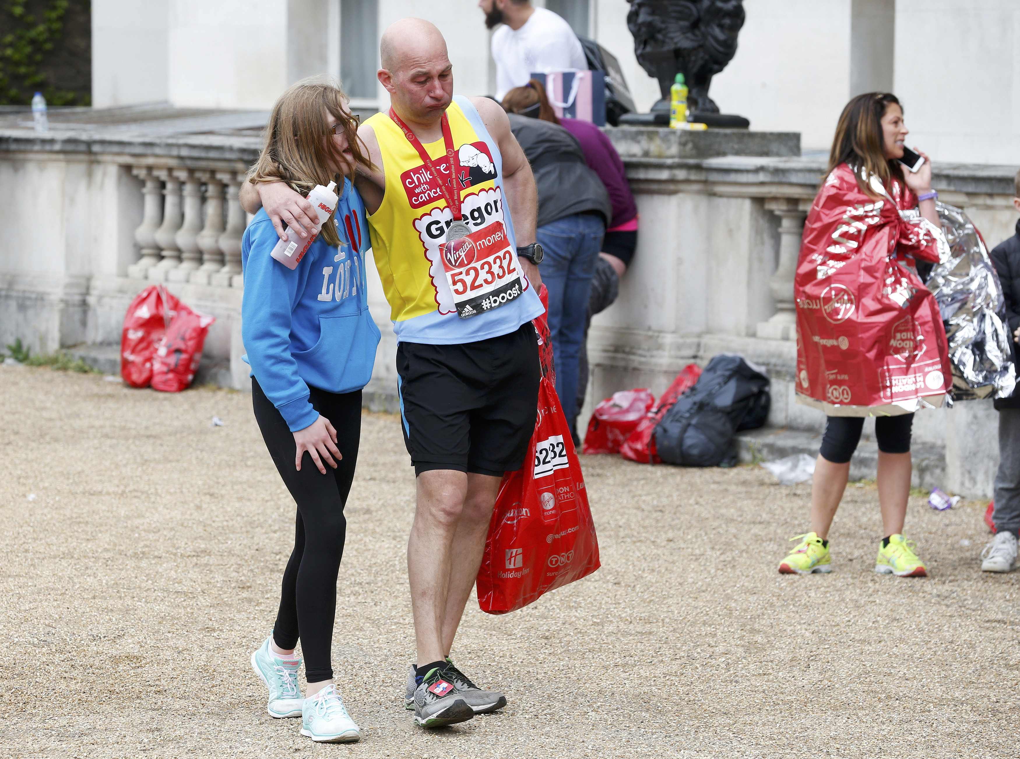 A runner gets a little help after finishing the London Marathon